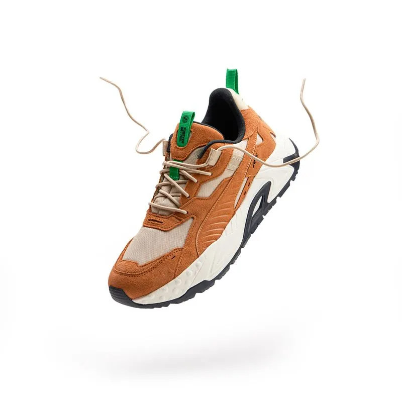 Orange and white running sneaker floating with its laces in the air