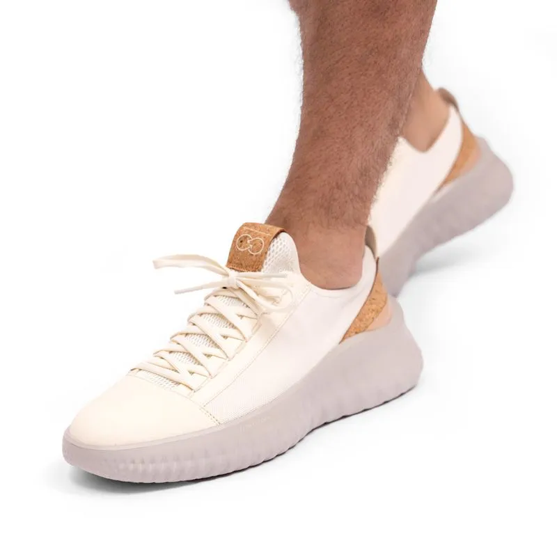 Model wearing white knit sneakers, cropped at the leg